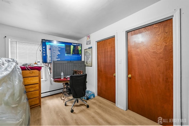 office space featuring light hardwood / wood-style floors and a baseboard heating unit