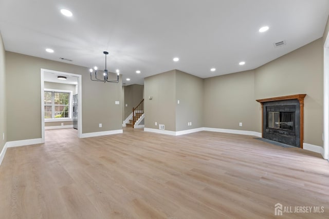 13 Stuart Dr Unit 5, Freehold, NJ 07728 - unfurnished living room with light wood-type flooring, a chandelier, a fireplace with flush hearth, stairs, and recessed lighting