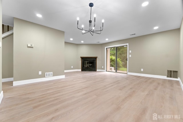 13 Stuart Dr Unit 5, Freehold, NJ 07728 - unfurnished living room with light wood-type flooring, a chandelier, recessed lighting, and a glass covered fireplace