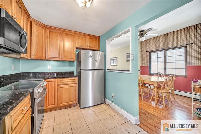 146 Arlington Dr, Fords, NJ 08863 - kitchen with appliances with stainless steel finishes, dark stone counters, brown cabinetry, a ceiling fan, and baseboards