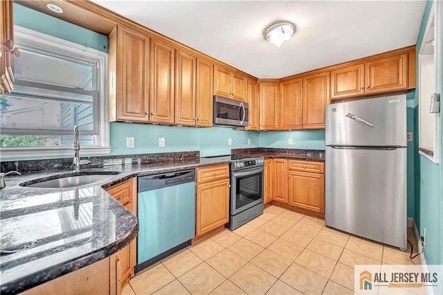 146 Arlington Dr, Fords, NJ 08863 - kitchen featuring stainless steel appliances, a sink, light tile patterned floors, dark stone countertops, and brown cabinets
