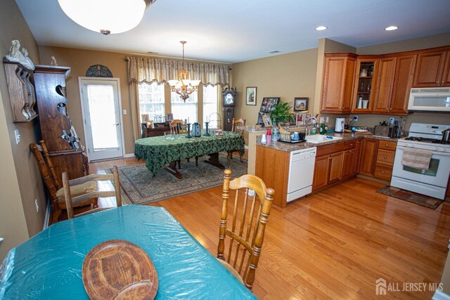 116 Prusakowski Blvd, Sayreville, NJ 08859 - kitchen featuring a notable chandelier, a sink, light wood finished floors, white appliances, and brown cabinetry