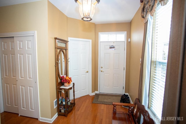 116 Prusakowski Blvd, Sayreville, NJ 08859 - entryway featuring baseboards, visible vents, wood finished floors, and an inviting chandelier