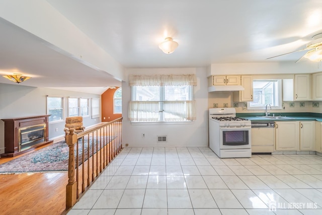 289 Old Rd, Sewaren, NJ 07077 - kitchen with white appliances, under cabinet range hood, a sink, and healthy amount of natural light