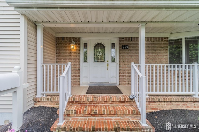 289 Old Rd, Sewaren, NJ 07077 - property entrance featuring a porch and brick siding