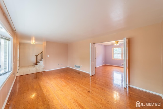 289 Old Rd, Sewaren, NJ 07077 - unfurnished room with stairway, light wood finished floors, and baseboards