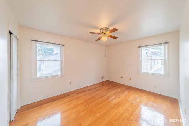 289 Old Rd, Sewaren, NJ 07077 - unfurnished bedroom featuring multiple windows, light wood-type flooring, baseboards, and ceiling fan