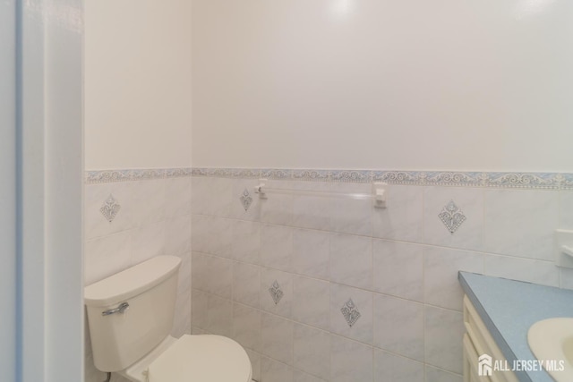 289 Old Rd, Sewaren, NJ 07077 - half bath with tile walls, toilet, vanity, and a wainscoted wall