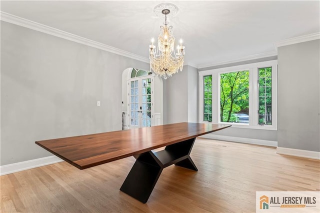 unfurnished dining area with french doors, baseboards, crown molding, and wood finished floors