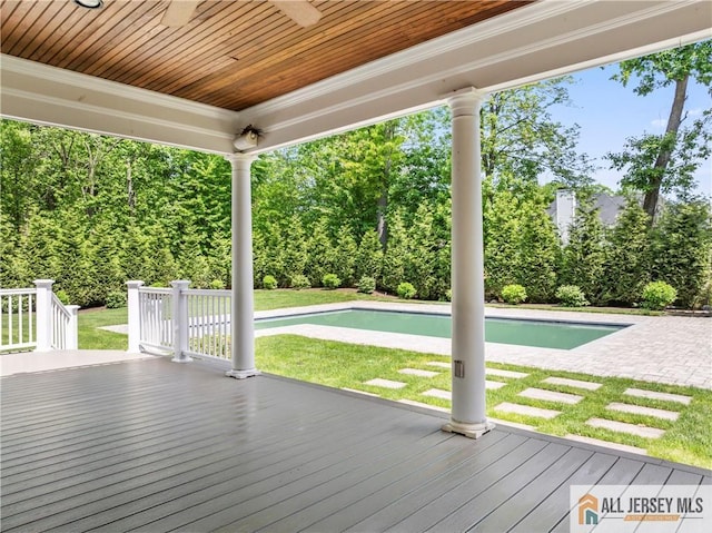 deck with ceiling fan, a lawn, and an outdoor pool