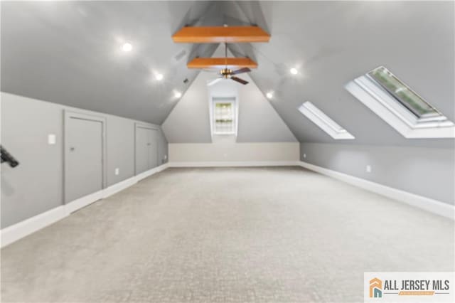 additional living space featuring carpet floors, baseboards, a skylight, and lofted ceiling