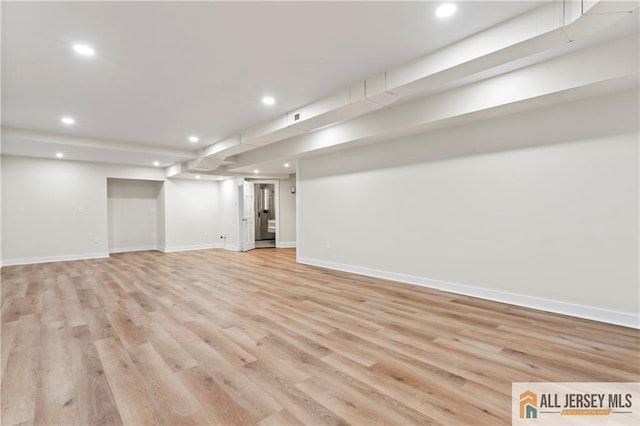 finished basement featuring recessed lighting, baseboards, and light wood-type flooring