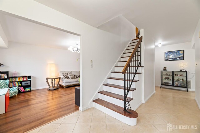 stairs featuring a chandelier and tile patterned flooring