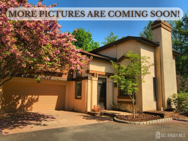 528 Sayre Dr, Plainsboro, NJ 08540 - view of front of home with a chimney, stucco siding, concrete driveway, and an attached garage