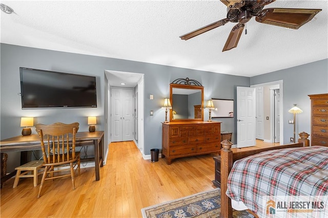 bedroom with ceiling fan, light wood-style flooring, baseboards, and a textured ceiling