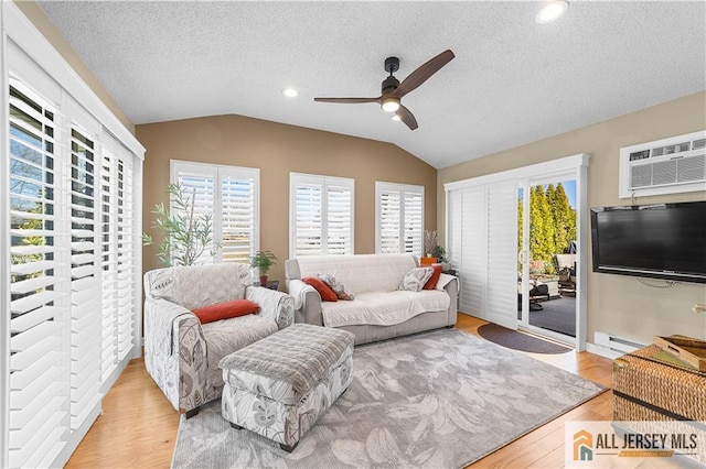 living room featuring a wall mounted air conditioner, lofted ceiling, a healthy amount of sunlight, and ceiling fan