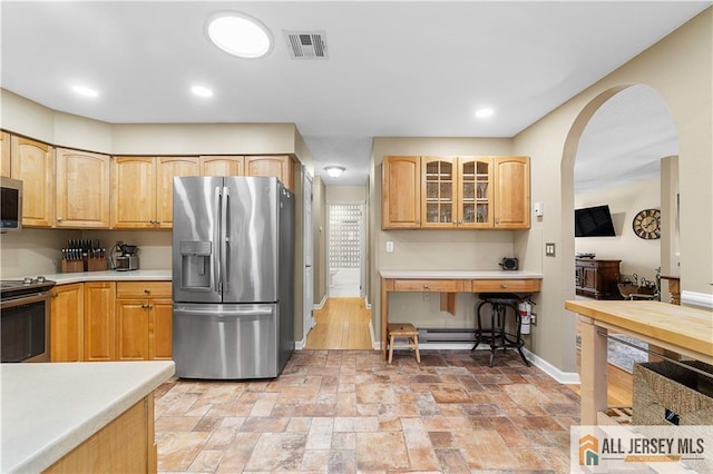 kitchen featuring visible vents, stainless steel appliances, arched walkways, light countertops, and glass insert cabinets