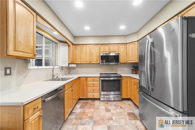 kitchen featuring light countertops, appliances with stainless steel finishes, and a sink