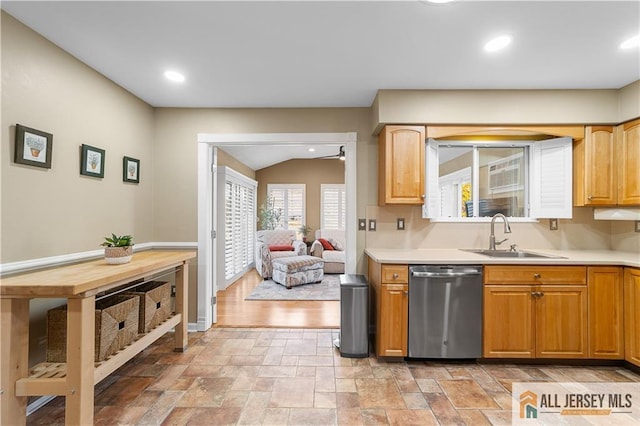 kitchen featuring stone finish flooring, light countertops, recessed lighting, stainless steel dishwasher, and a sink