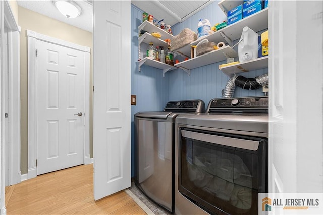 clothes washing area with separate washer and dryer, laundry area, and light wood finished floors