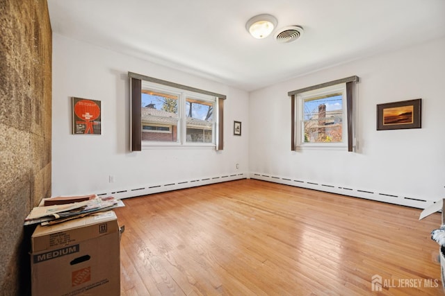spare room featuring visible vents and hardwood / wood-style floors
