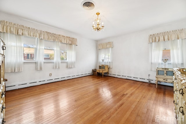 unfurnished room featuring visible vents, plenty of natural light, hardwood / wood-style floors, and a notable chandelier