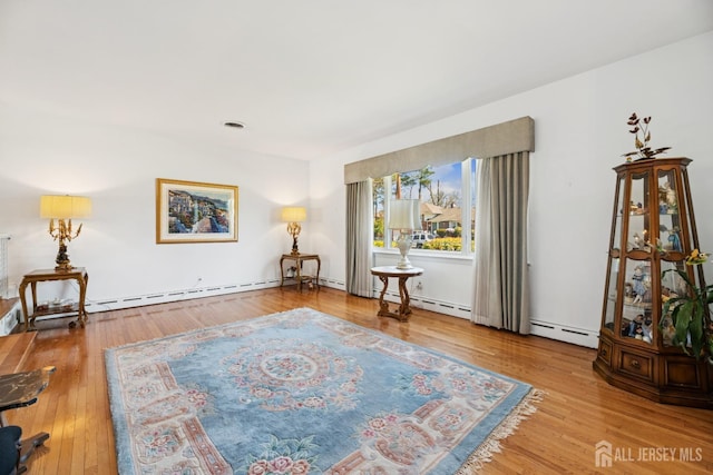 sitting room featuring baseboard heating and wood finished floors