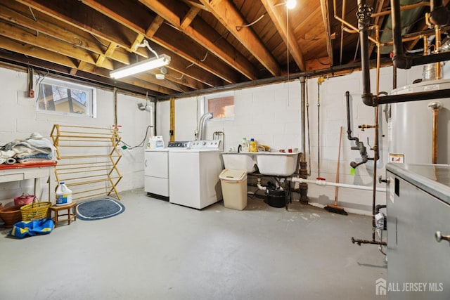 basement featuring concrete block wall and washing machine and clothes dryer