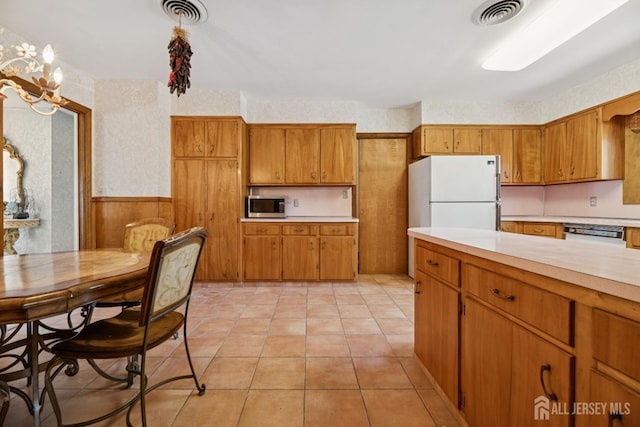 kitchen featuring visible vents, white appliances, light countertops, and wallpapered walls