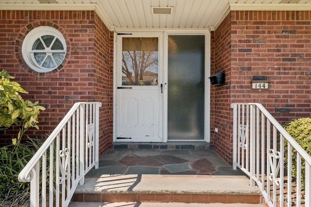 doorway to property with brick siding
