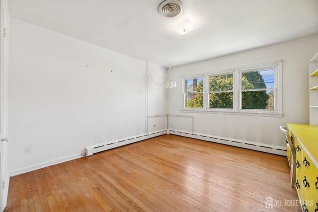 empty room featuring a baseboard radiator, visible vents, and light wood-type flooring