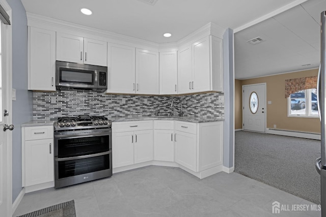 kitchen with white cabinetry, appliances with stainless steel finishes, light carpet, and tasteful backsplash