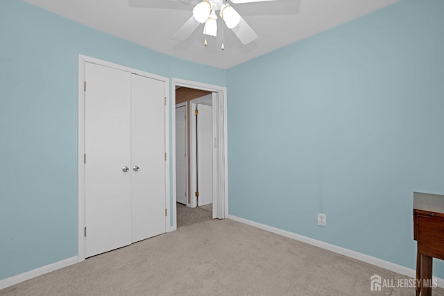 unfurnished bedroom featuring light carpet, a closet, and ceiling fan