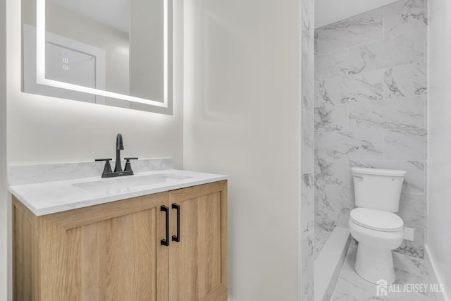 bathroom featuring vanity, tile walls, and toilet