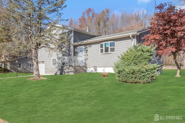 back of property featuring a garage and a yard