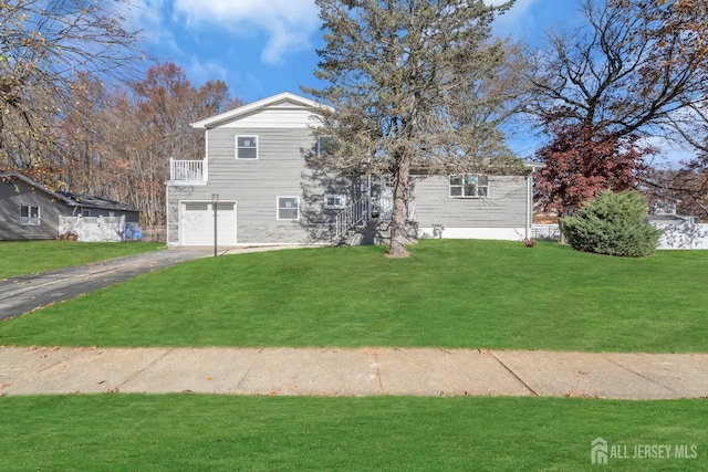 view of front of home featuring a balcony, a garage, and a front lawn