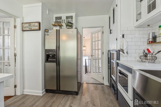 1 Hollywood Dr, Woodbridge Proper, NJ 07095 - kitchen featuring stainless steel refrigerator with ice dispenser, wood finished floors, white cabinetry, and tasteful backsplash