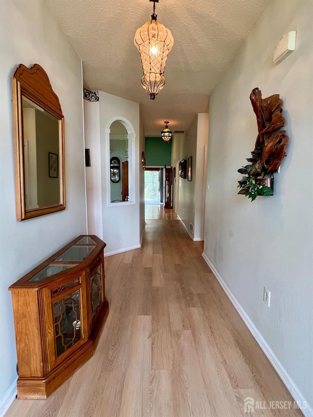 1 Walter Way, Monroe, NJ 08831 - corridor featuring a textured ceiling, light wood finished floors, arched walkways, and a chandelier