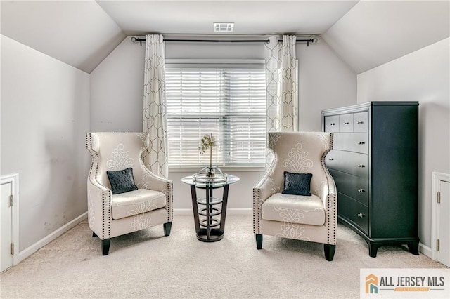 living area with visible vents, baseboards, carpet, and vaulted ceiling