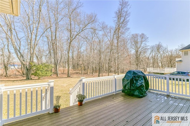 wooden deck featuring a lawn and area for grilling