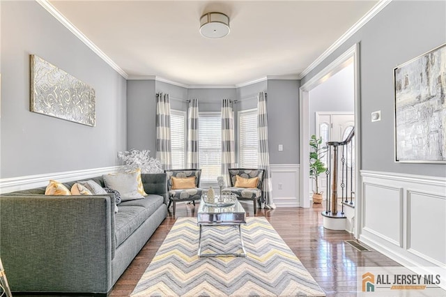 living area featuring visible vents, dark wood finished floors, and ornamental molding