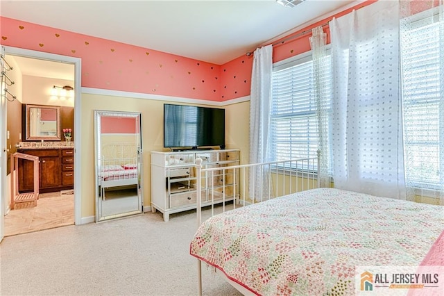 bedroom featuring ensuite bath and carpet