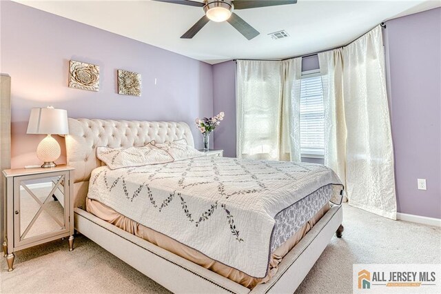 carpeted bedroom with visible vents, baseboards, and ceiling fan