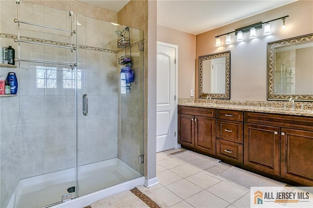 full bathroom with tile patterned flooring, a shower stall, double vanity, and a sink