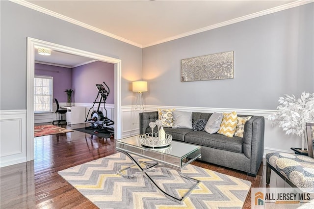 living area featuring a decorative wall, wood finished floors, wainscoting, and ornamental molding