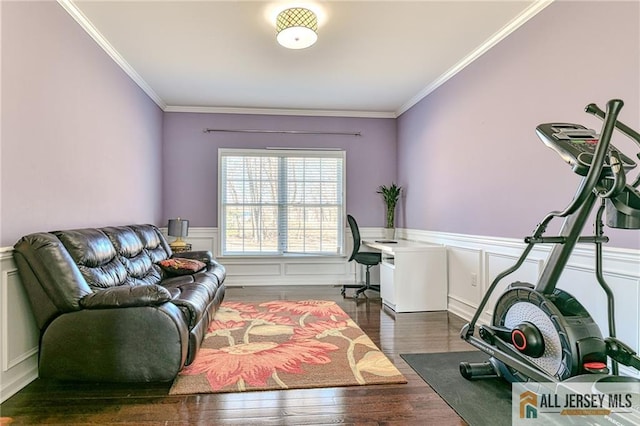 office featuring crown molding, a decorative wall, wood finished floors, and wainscoting