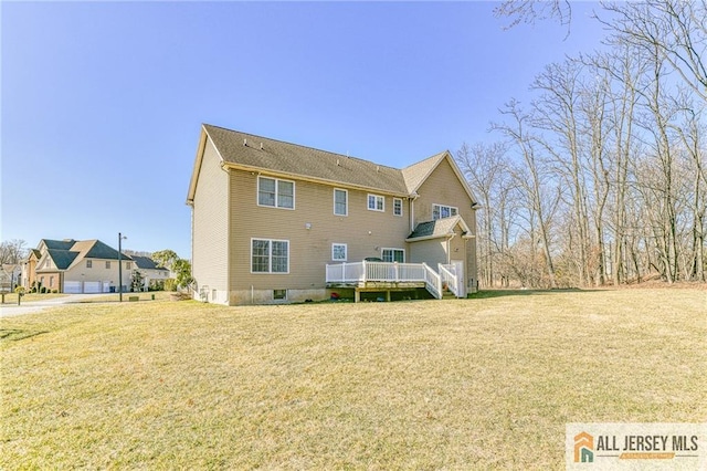 back of house with a wooden deck and a lawn