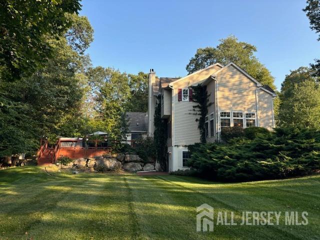 1 Mayfair Ln, Byram, NJ 07821 - view of side of property featuring a yard, a chimney, and a wooden deck