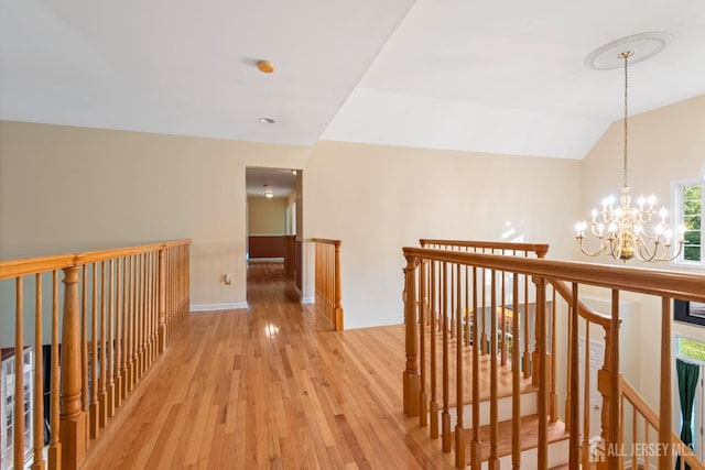 1 Mayfair Ln, Byram, NJ 07821 - corridor featuring a notable chandelier, an upstairs landing, baseboards, and light wood-type flooring