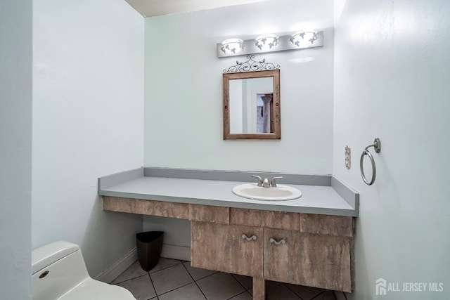 bathroom with toilet, tile patterned flooring, and vanity